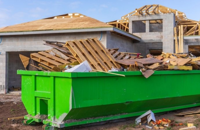 green dumpster full of construction trash