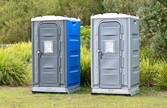 two portable toilets in a field