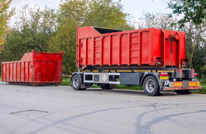 two red roll off containers in the road